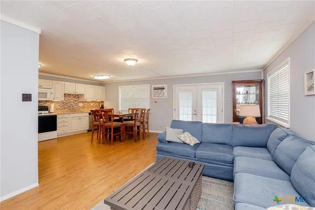 a living room with lots of furniture and kitchen view