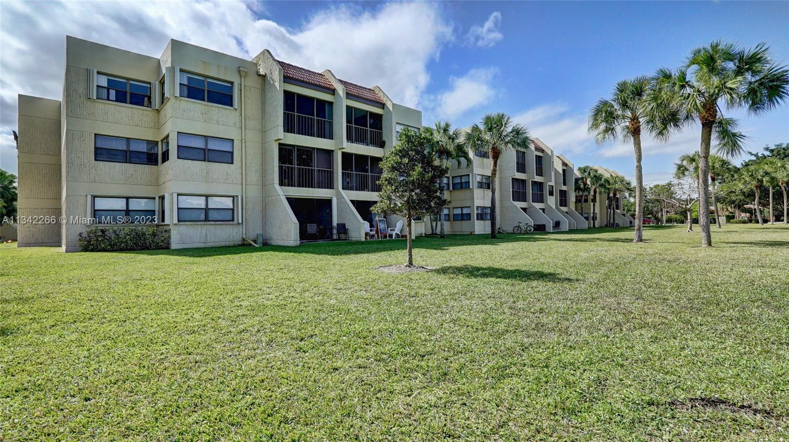 Racquet Club Apartments at Bonaventure Weston, FL 33326 - Photo 25 of 26 a view of a house with a yard and palm trees
