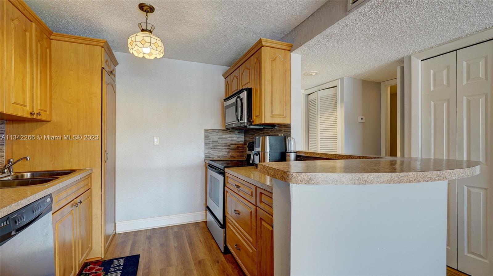 Racquet Club Apartments at Bonaventure Weston, FL 33326 - Photo 7 of 26 a kitchen with granite countertop a sink stove and refrigerator
