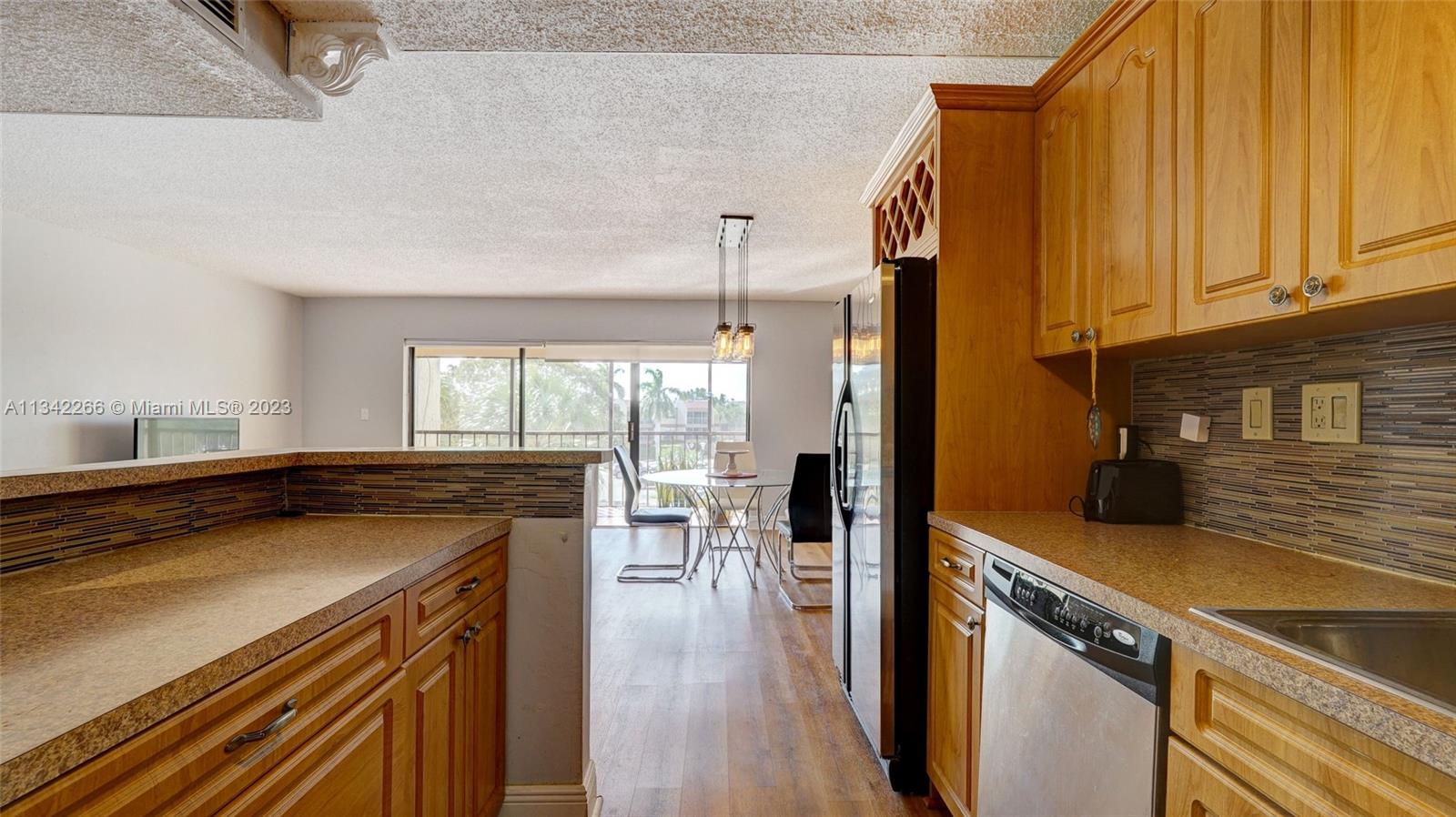 Racquet Club Apartments at Bonaventure Weston, FL 33326 - Photo 8 of 26 a kitchen with a sink a stove and cabinets