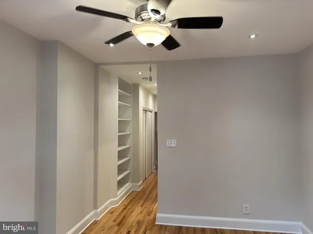 a view of a hallway with a chandelier fan and wooden floor