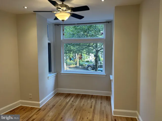 a view of a room with wooden floor and a window