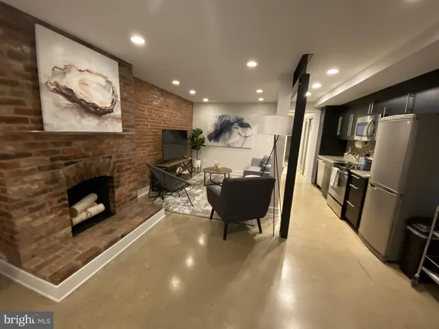 a living room with furniture a flat screen tv and a fireplace