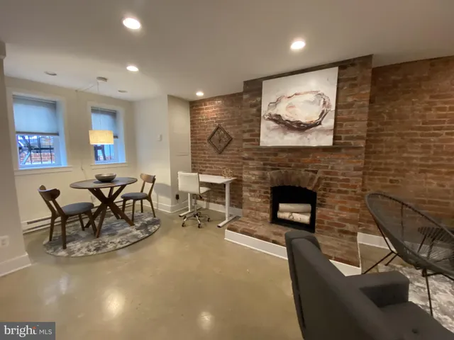 a living room with furniture a flat screen tv and a fireplace