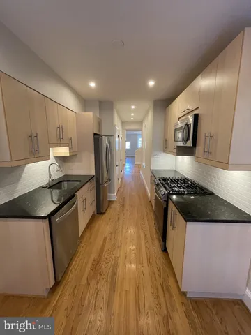 a kitchen with stainless steel appliances granite countertop a stove a sink and a refrigerator