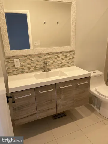 a bathroom with a sink a toilet and mirror