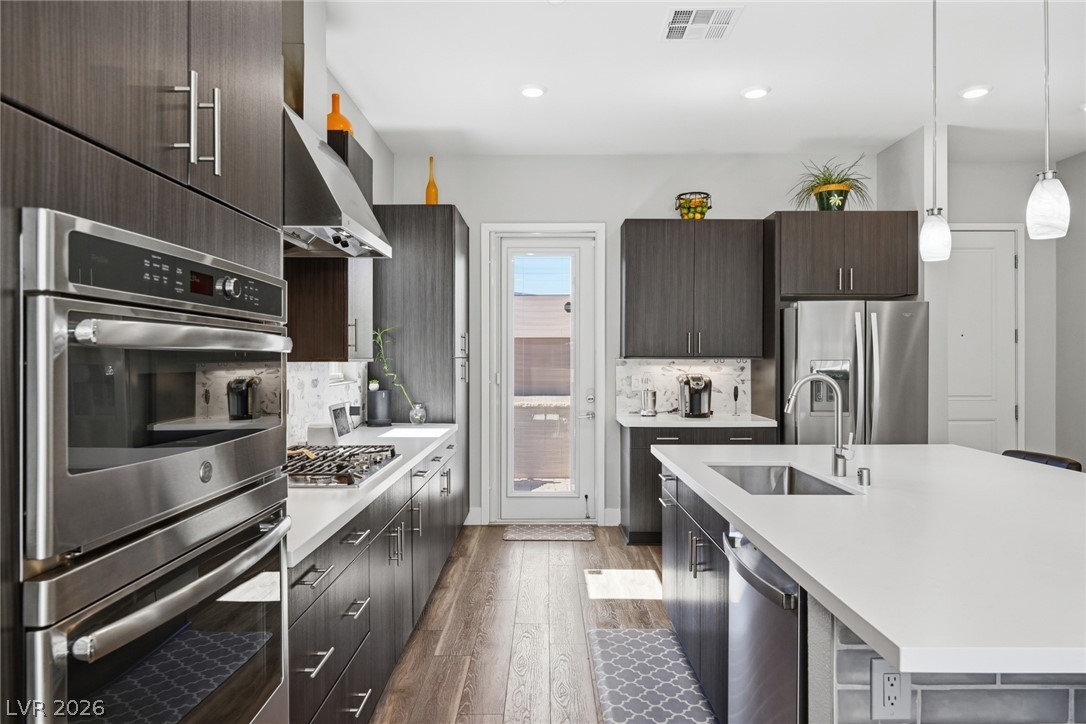 4246 Swift Street Las Vegas, NV 89135 - Photo 18 of 71 Kitchen with stainless steel appliances, backsplash, dark wood-type flooring, modern cabinets, and dark wood finish cabinets
