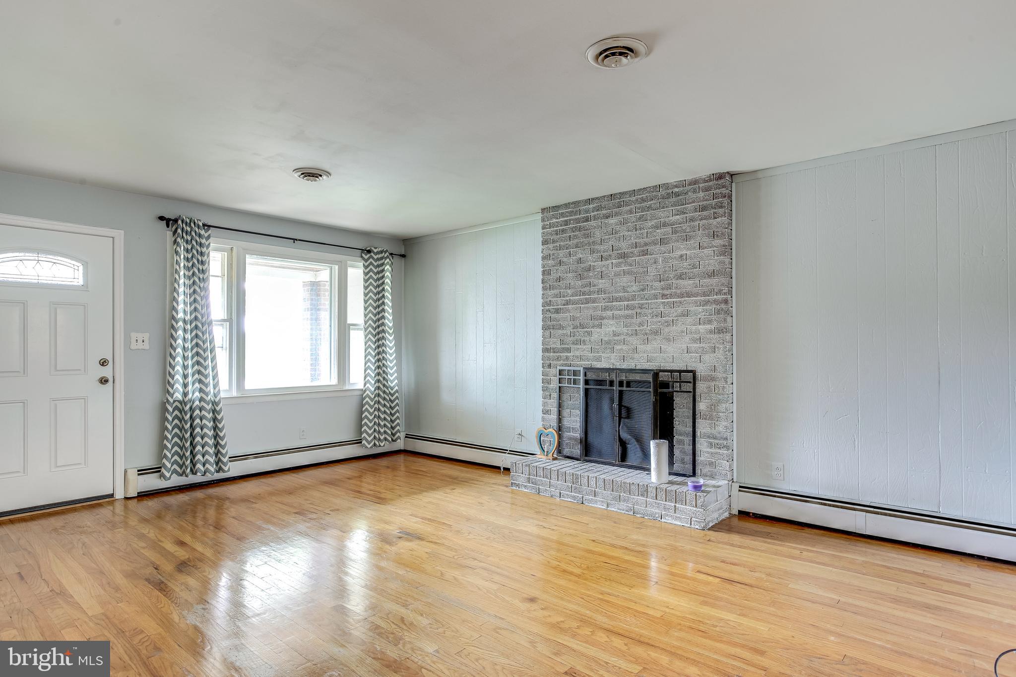 312 Savannah Road Baltimore, MD 21221 - Photo 5 of 29 Living Room w/ Brick Surround Wood Fireplace