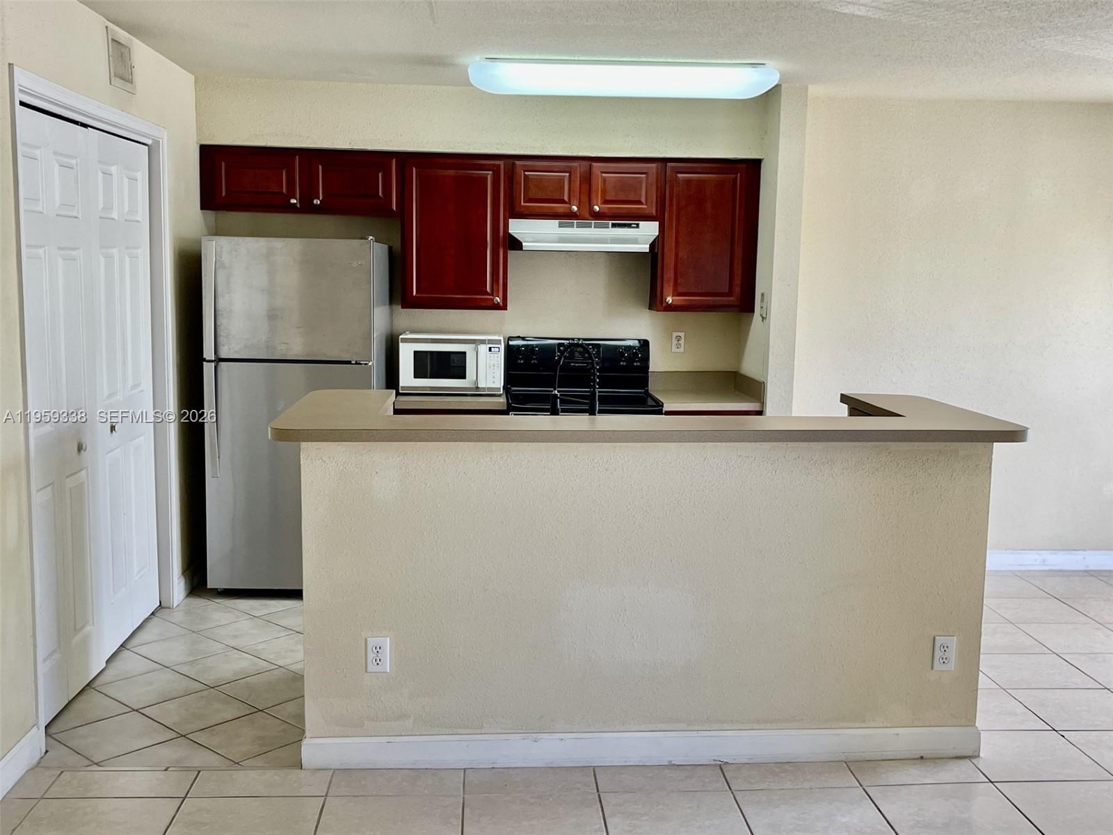 977 Riverside Drive, Unit 227 Coral Springs, FL 33071 - Photo 14 of 36 a kitchen with stainless steel appliances a refrigerator and a stove