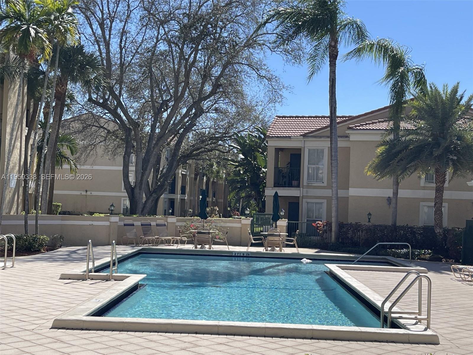 977 Riverside Drive, Unit 227 Coral Springs, FL 33071 - Photo 2 of 36 a view of a patio with swimming pool table and chairs