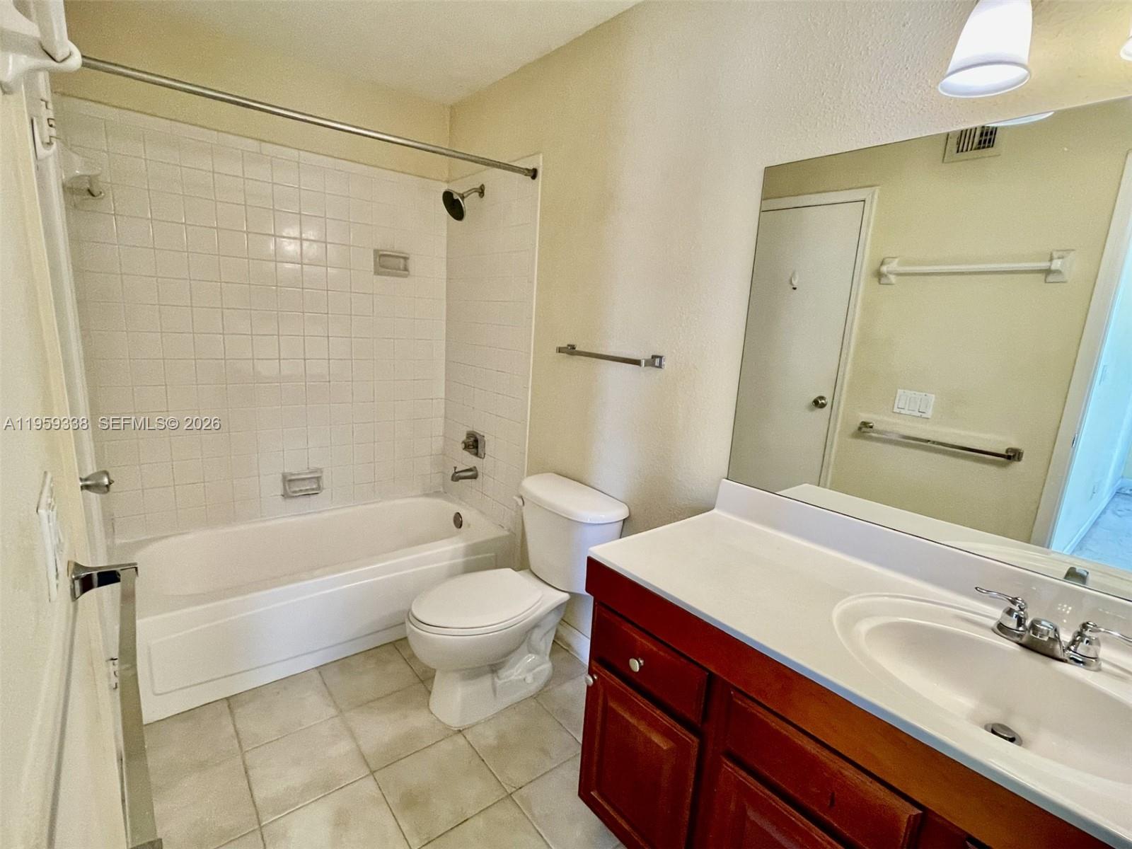 977 Riverside Drive, Unit 227 Coral Springs, FL 33071 - Photo 8 of 36 a bathroom with a sink a toilet a mirror a bathtub and shower