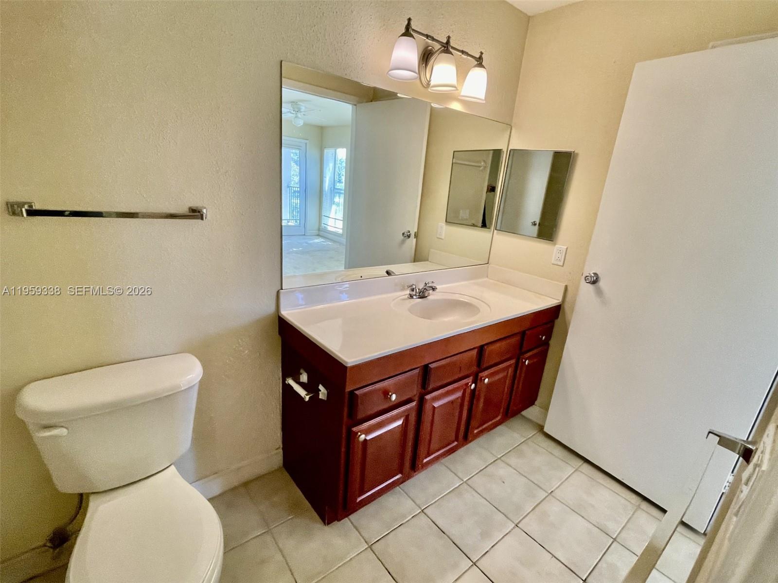 977 Riverside Drive, Unit 227 Coral Springs, FL 33071 - Photo 9 of 36 a bathroom with a sink a toilet and mirror