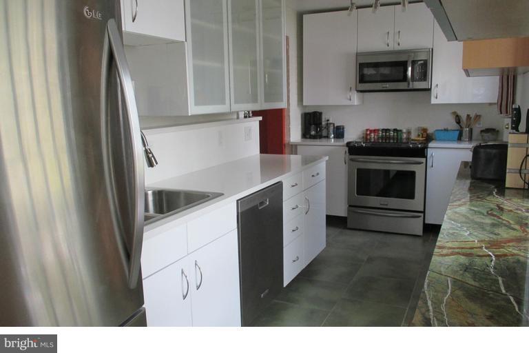 2444 Pickwick Road Baltimore, MD 21207 - Photo 8 of 24 a kitchen with stainless steel appliances granite countertop a stove a sink and a refrigerator