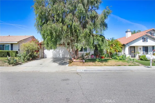 a view of a house with a small yard and potted plants