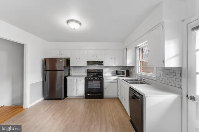 a kitchen with a sink a refrigerator and a stove top oven