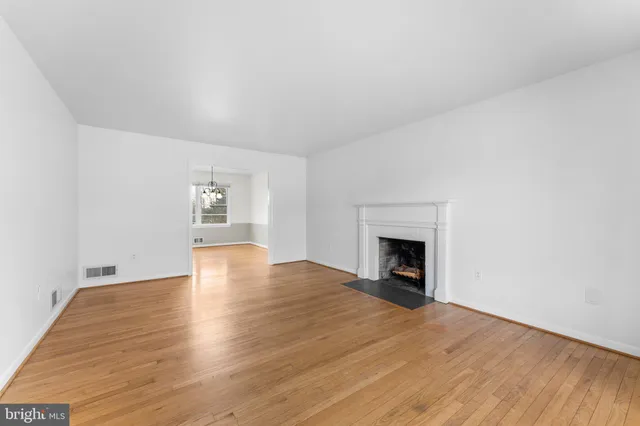 a view of empty room with wooden floor and fireplace