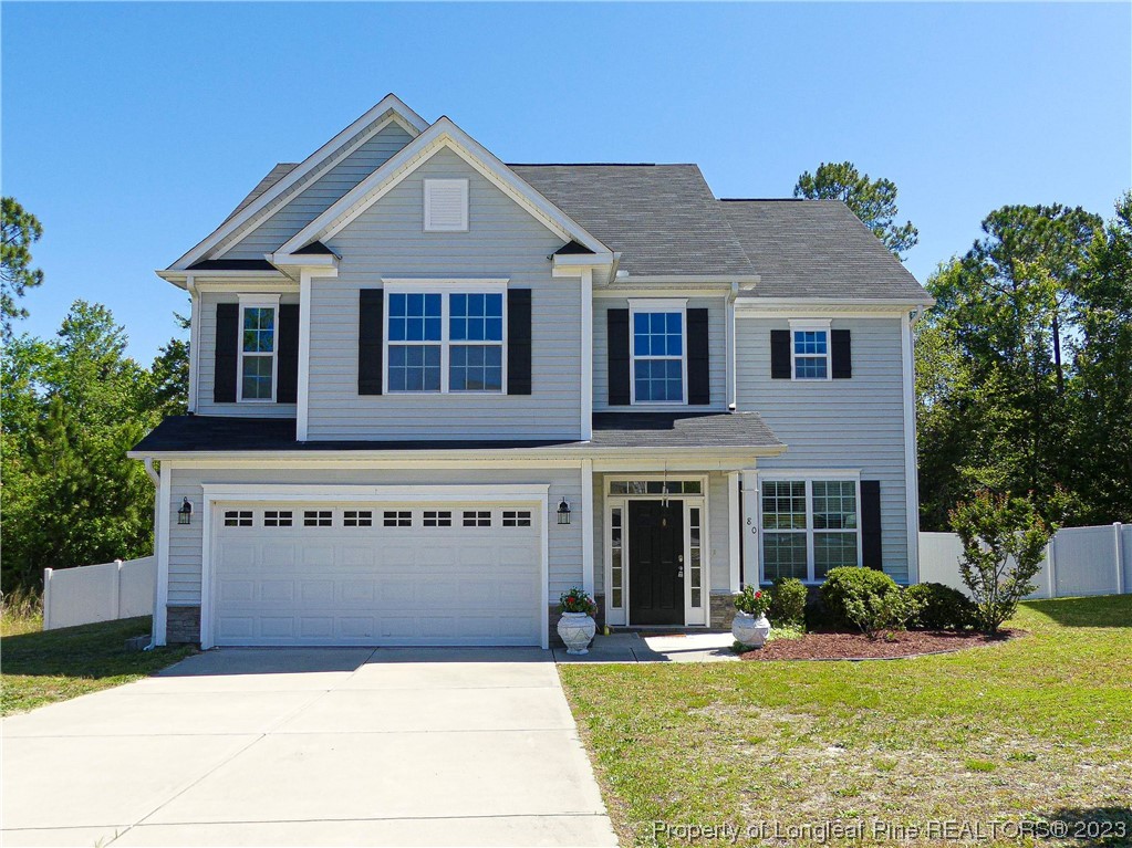 a front view of a house with yard and garage
