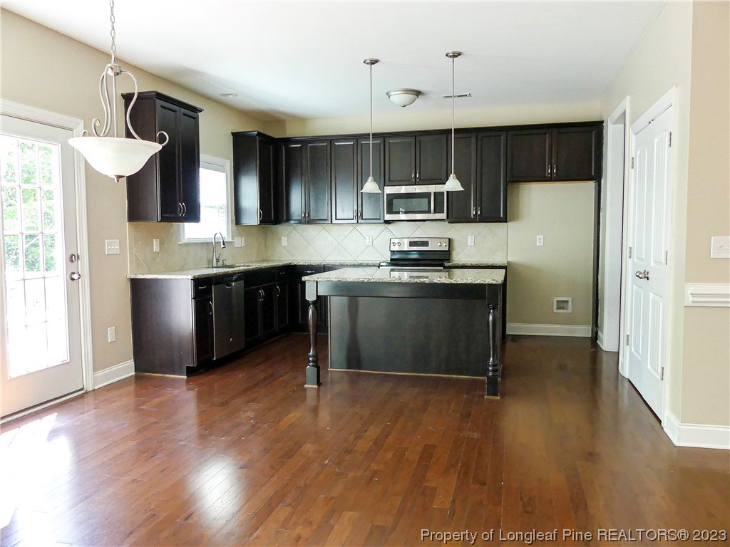 80 Pedley Place Cameron, NC 28326 - Photo 11 of 34 a kitchen with stainless steel appliances granite countertop a stove a refrigerator a sink dishwasher and white cabinets with wooden floor