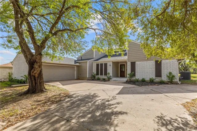 a front view of a house with a yard and trees