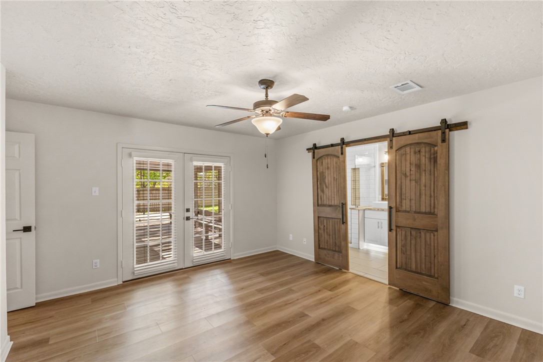 2511 Arbor Drive Bryan, TX 77802 - Photo 19 of 36 an empty room with wooden floor chandelier fan and windows