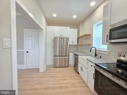 a kitchen with stainless steel appliances granite countertop a refrigerator sink and stove