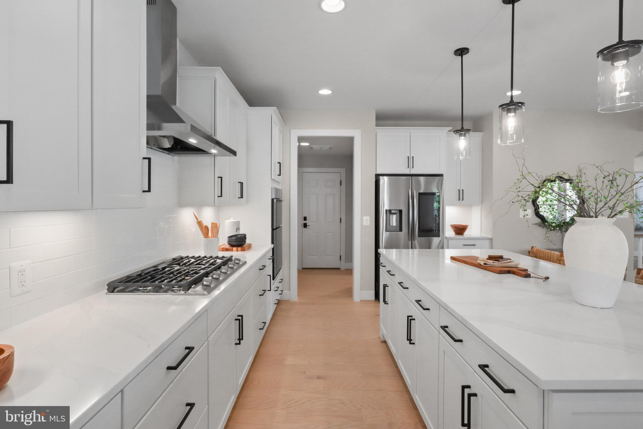602 Kingsley Road Southwest Vienna, VA 22180 - Photo 25 of 79 a kitchen with stainless steel appliances a refrigerator a sink dishwasher a stove and white cabinets with wooden floor