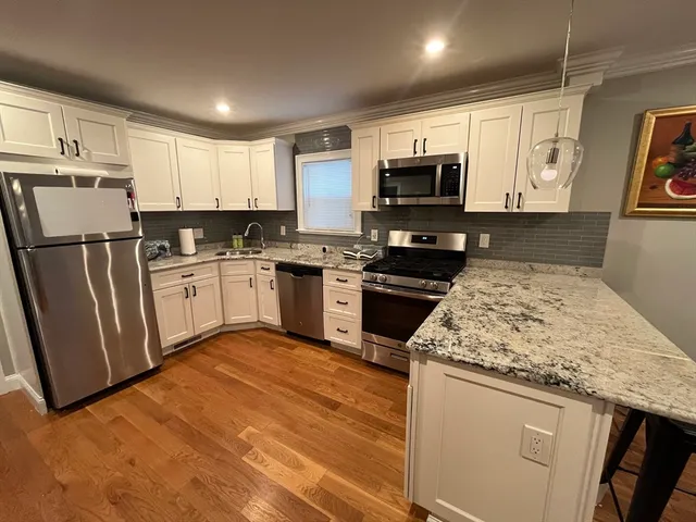 a kitchen with granite countertop a sink stove and refrigerator