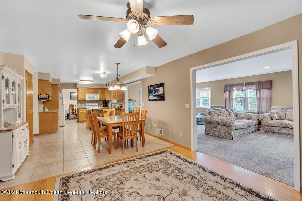 587 Reed Road Jackson, NJ 08527 - Photo 7 of 26 a dining room with wooden floor and a rug