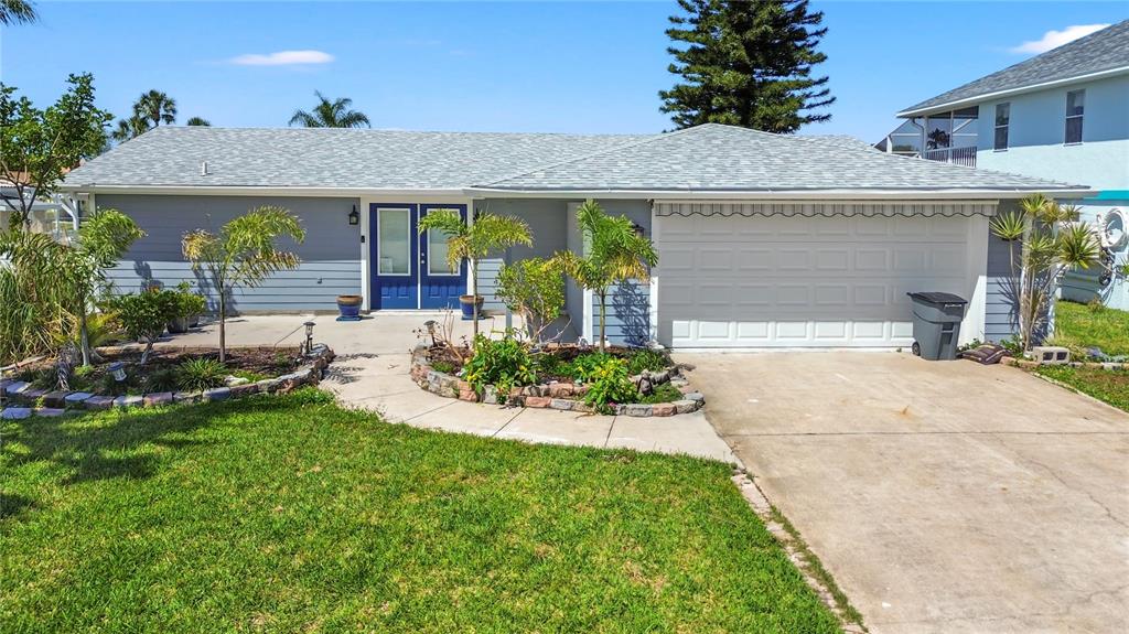 9917 San Sierra Way Port Richey, FL 34668 - Photo 14 of 33 a front view of a house with a garden and patio