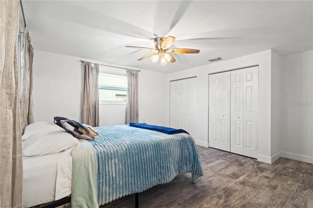 9917 San Sierra Way Port Richey, FL 34668 - Photo 17 of 33 a bedroom with a bed and a chandelier