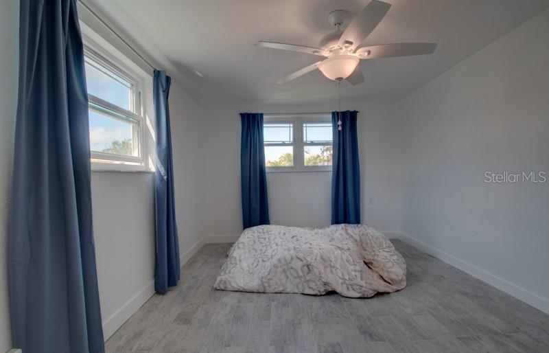 9917 San Sierra Way Port Richey, FL 34668 - Photo 22 of 33 a bedroom with a large bed and a chandelier