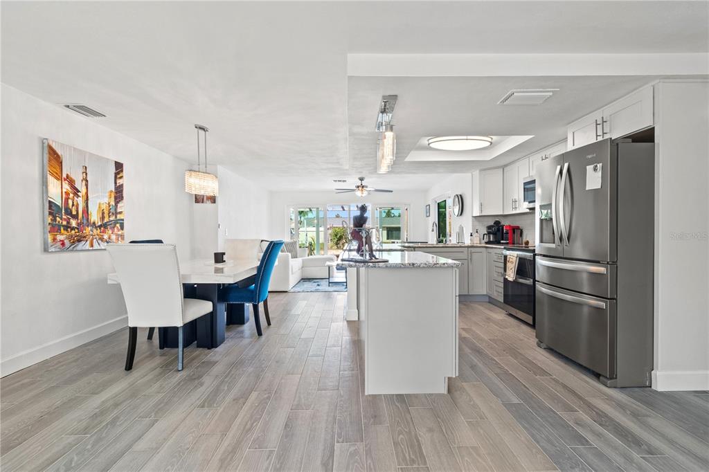 9917 San Sierra Way Port Richey, FL 34668 - Photo 10 of 33 a kitchen with stainless steel appliances wooden floor and dining table