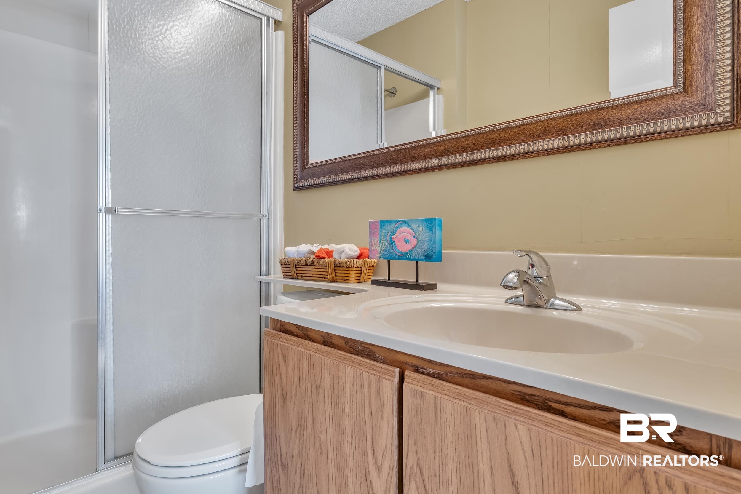 3256 Loop Road, Unit 2 Orange Beach, AL 36561 - Photo 21 of 25 Bathroom featuring a wood-finish vanity with an integrated sink, polished chrome faucet, and a large mirror with an ornate frame