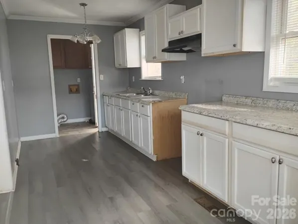 a kitchen with granite countertop white cabinets and window