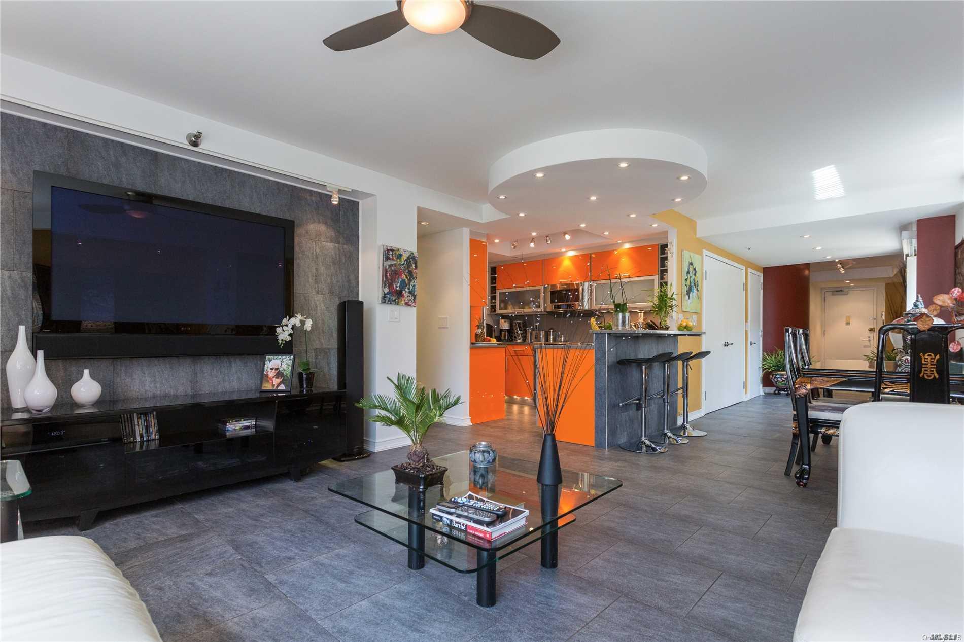 88 Cutter Mill Road, Unit 222 Great Neck, NY 11021 - Photo 1 of 1 a living room with furniture kitchen view and a flat screen tv