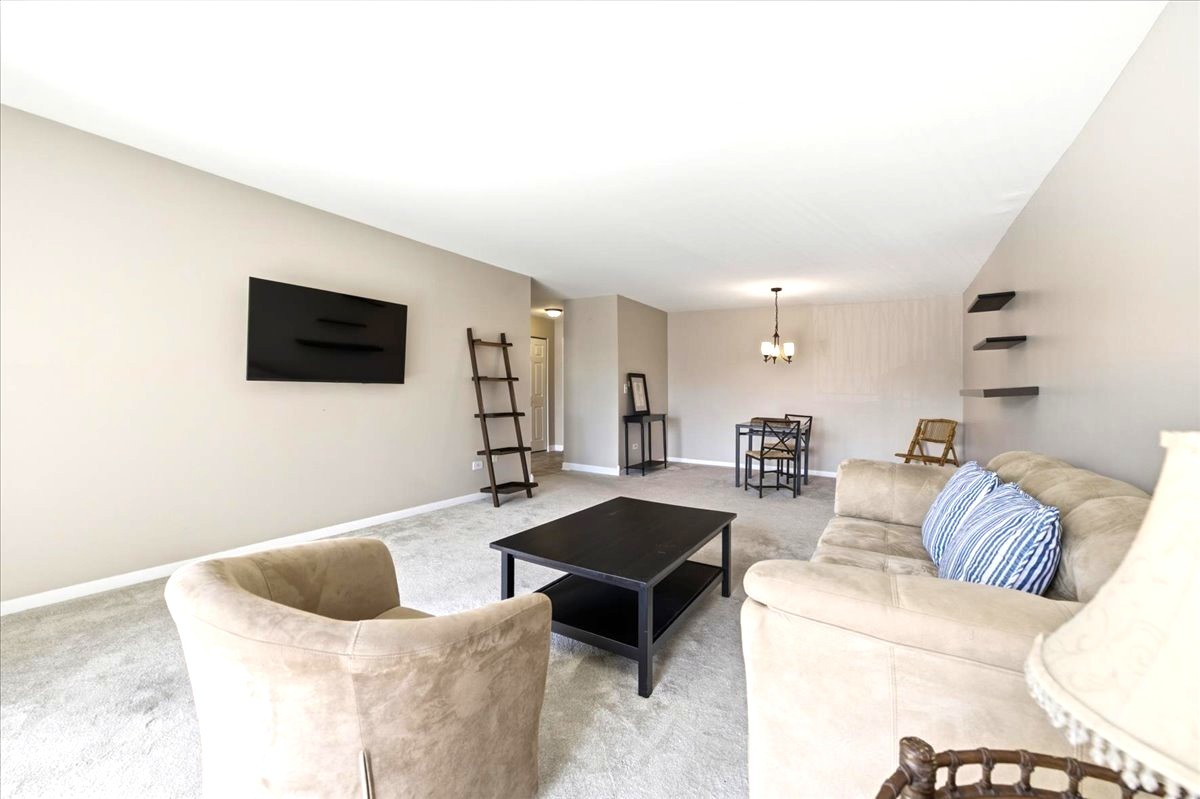 1311 South Finley Road, Unit 203 Lombard, IL 60148 - Photo 3 of 20 a living room with furniture and a flat screen tv