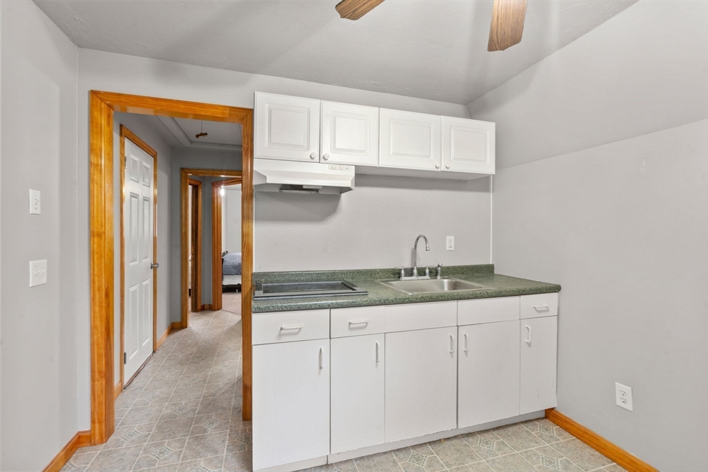 130 Old Barnstable Road Falmouth, MA 02536 - Photo 18 of 38 a hallway with granite countertop white cabinets and a sink