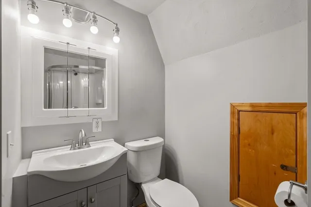 a bathroom with a toilet a sink and mirror