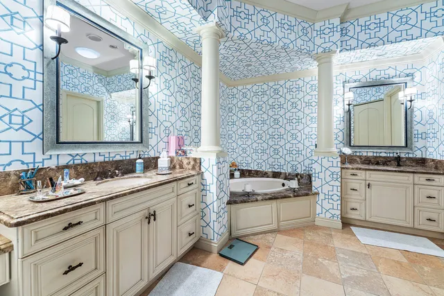 a spacious bathroom with a granite countertop double vanity sink a mirror and a