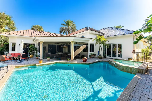 a view of a house with swimming pool and sitting area