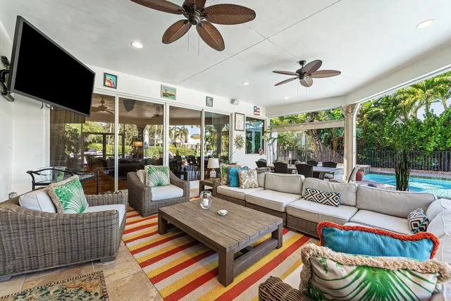 a living room with patio furniture and a large window