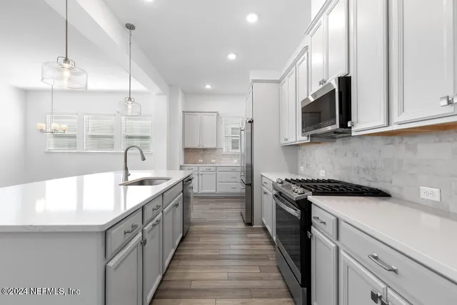 a kitchen with kitchen island granite countertop a sink and a stove top oven