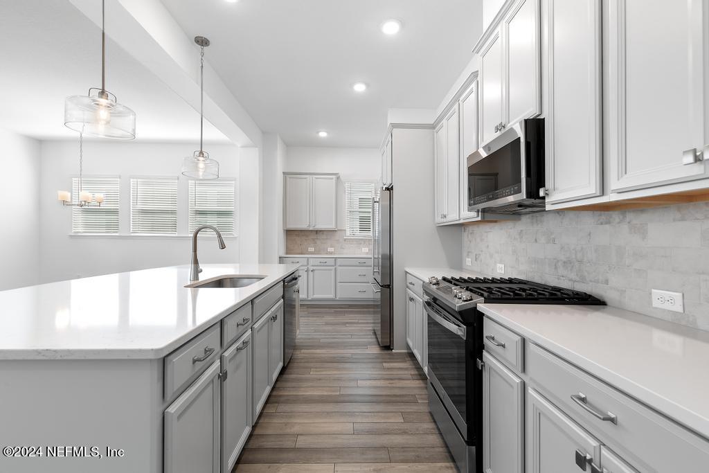 116 Alston Dr Street St. Augustine, FL 32092 - Photo 12 of 58 a kitchen with kitchen island granite countertop a sink and a stove top oven