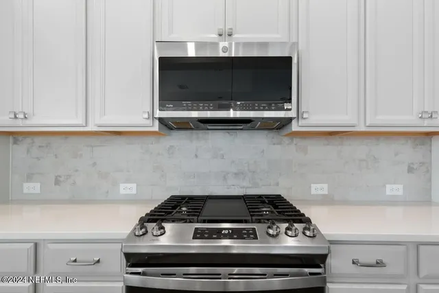 a stove top oven sitting inside of a kitchen
