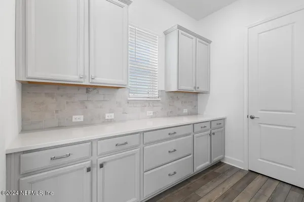 a large kitchen with stainless steel appliances a large counter top a stove and a refrigerator