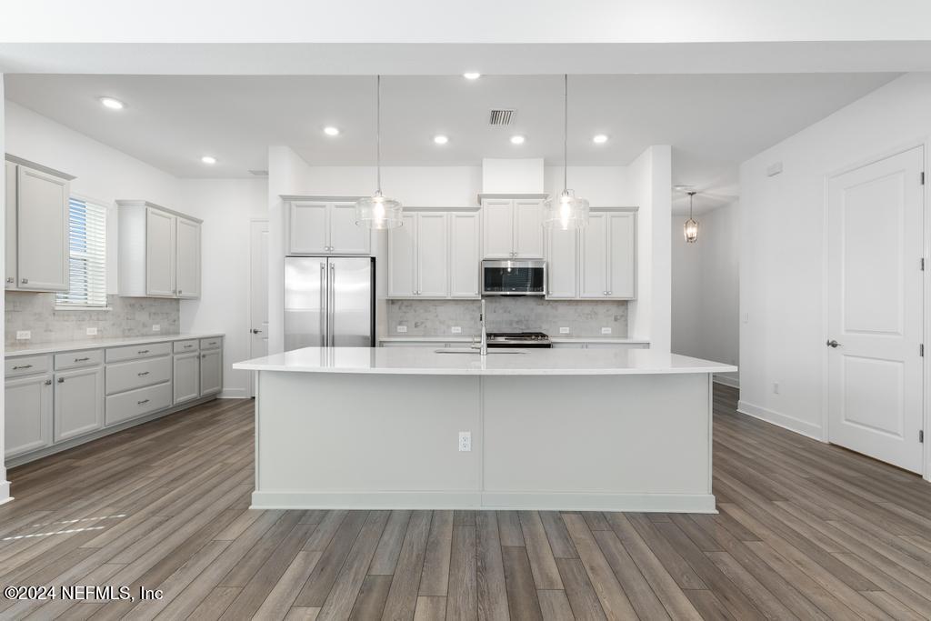 116 Alston Dr Street St. Augustine, FL 32092 - Photo 17 of 58 a large kitchen with stainless steel appliances a large counter top a stove and a refrigerator