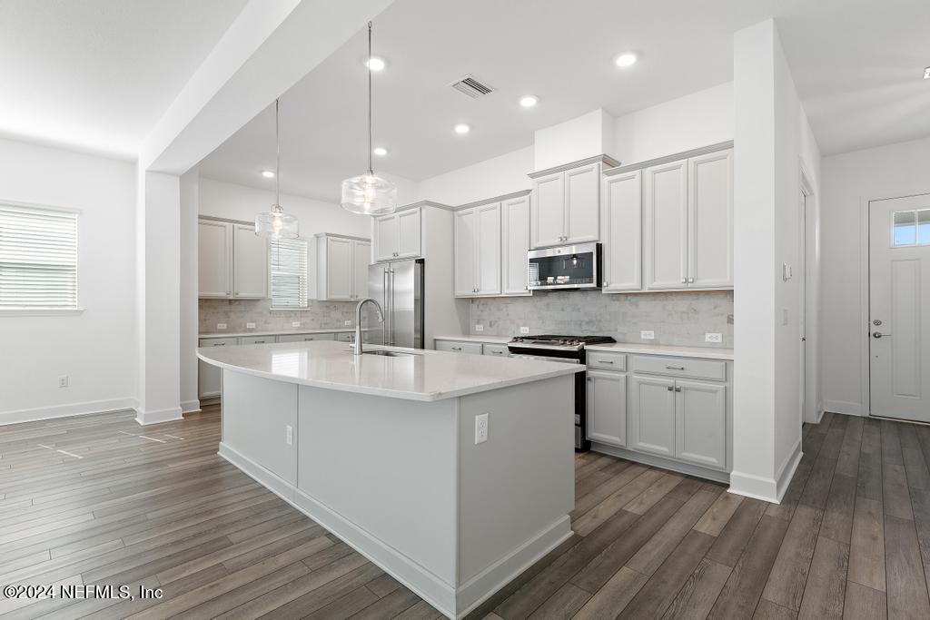 116 Alston Dr Street St. Augustine, FL 32092 - Photo 18 of 58 a kitchen with kitchen island granite countertop a sink cabinets and wooden floor