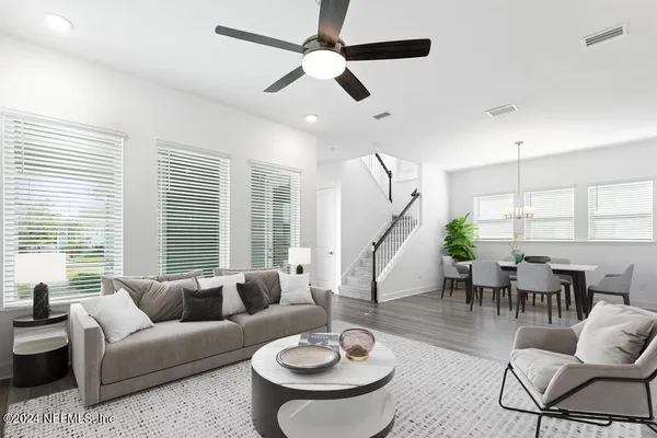 a large kitchen with kitchen island a refrigerator a stove a sink dishwasher a dining table and chairs with wooden floor