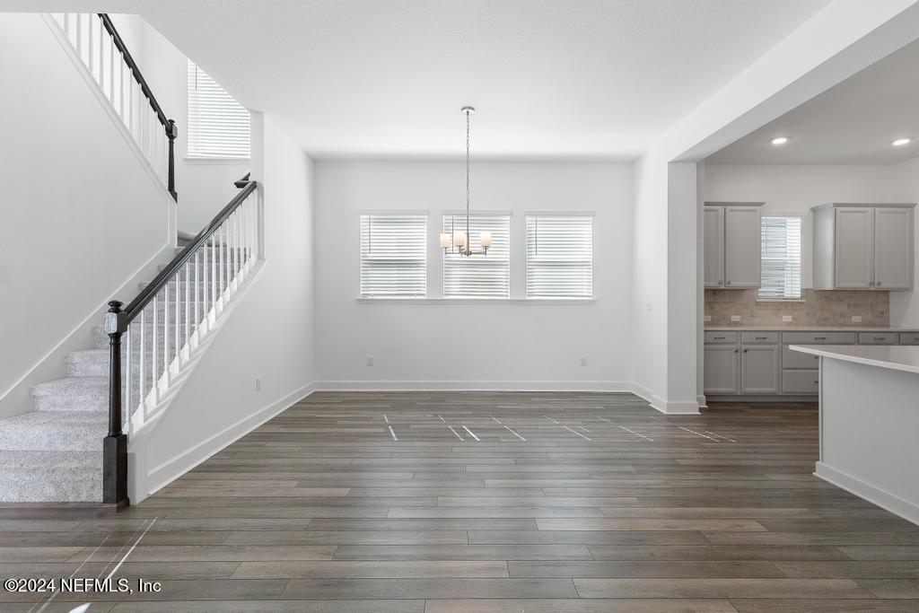 116 Alston Dr Street St. Augustine, FL 32092 - Photo 20 of 58 a view of an empty room with wooden floor and a kitchen