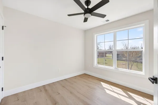 a view of empty room with wooden floor